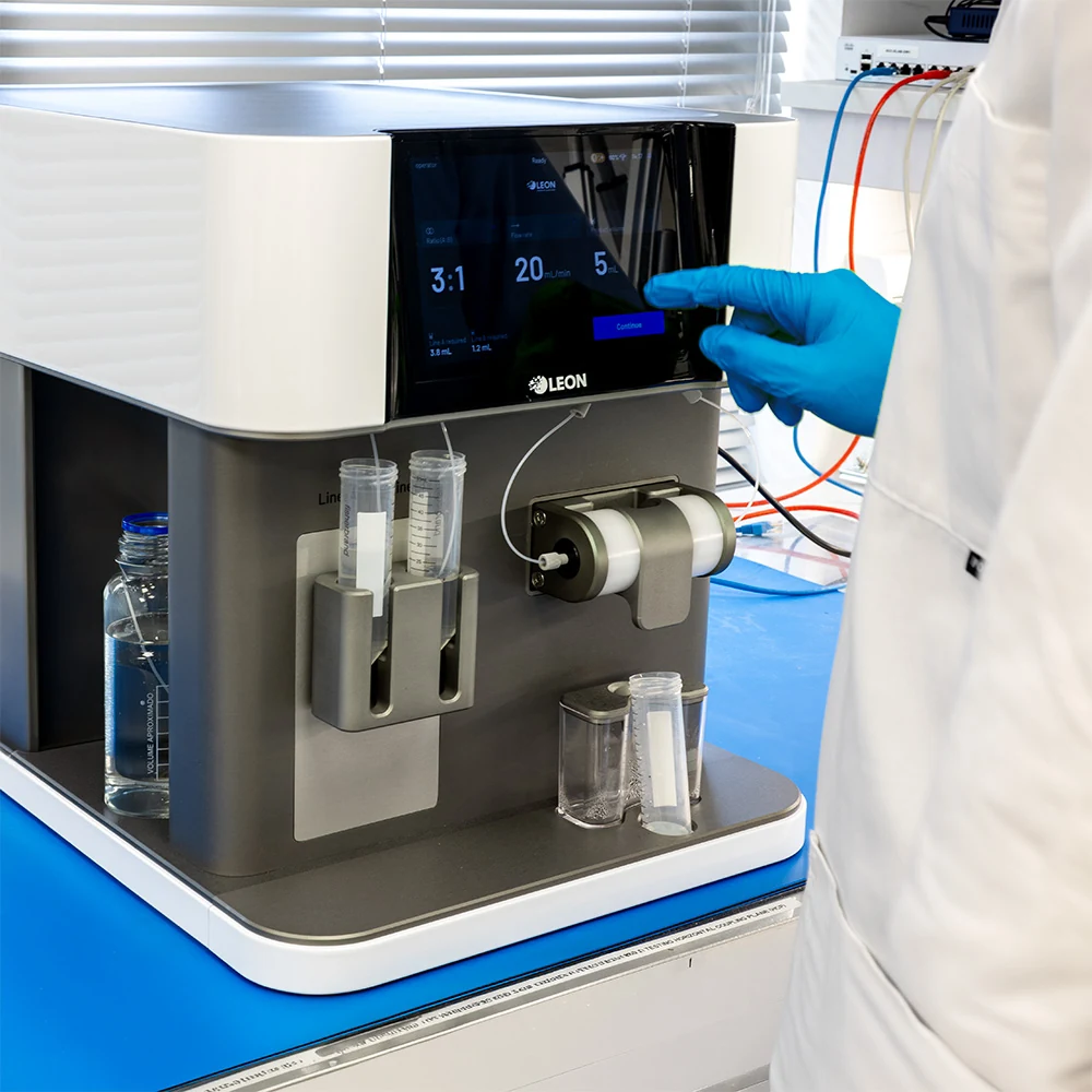 Scientist in a lab coat and blue gloves operating the NANOscreen® touchscreen